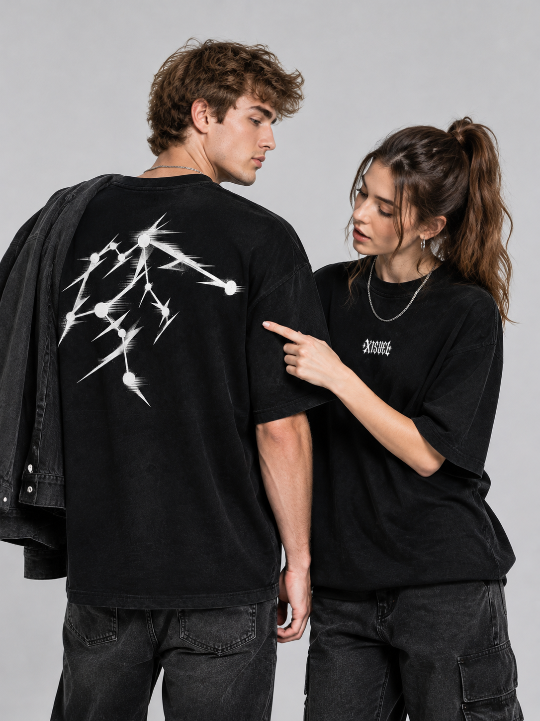 Couple wearing matching black XISVEL graphic tees, showing the Aquarius constellation back print