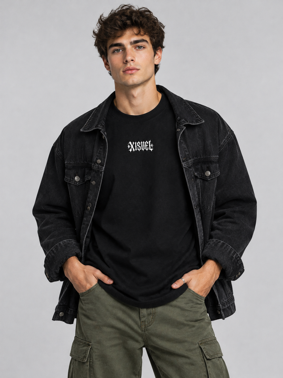 Male model wearing the black Aries Dark Graphic Tee with gothic XISVEL chest logo under an open denim jacket