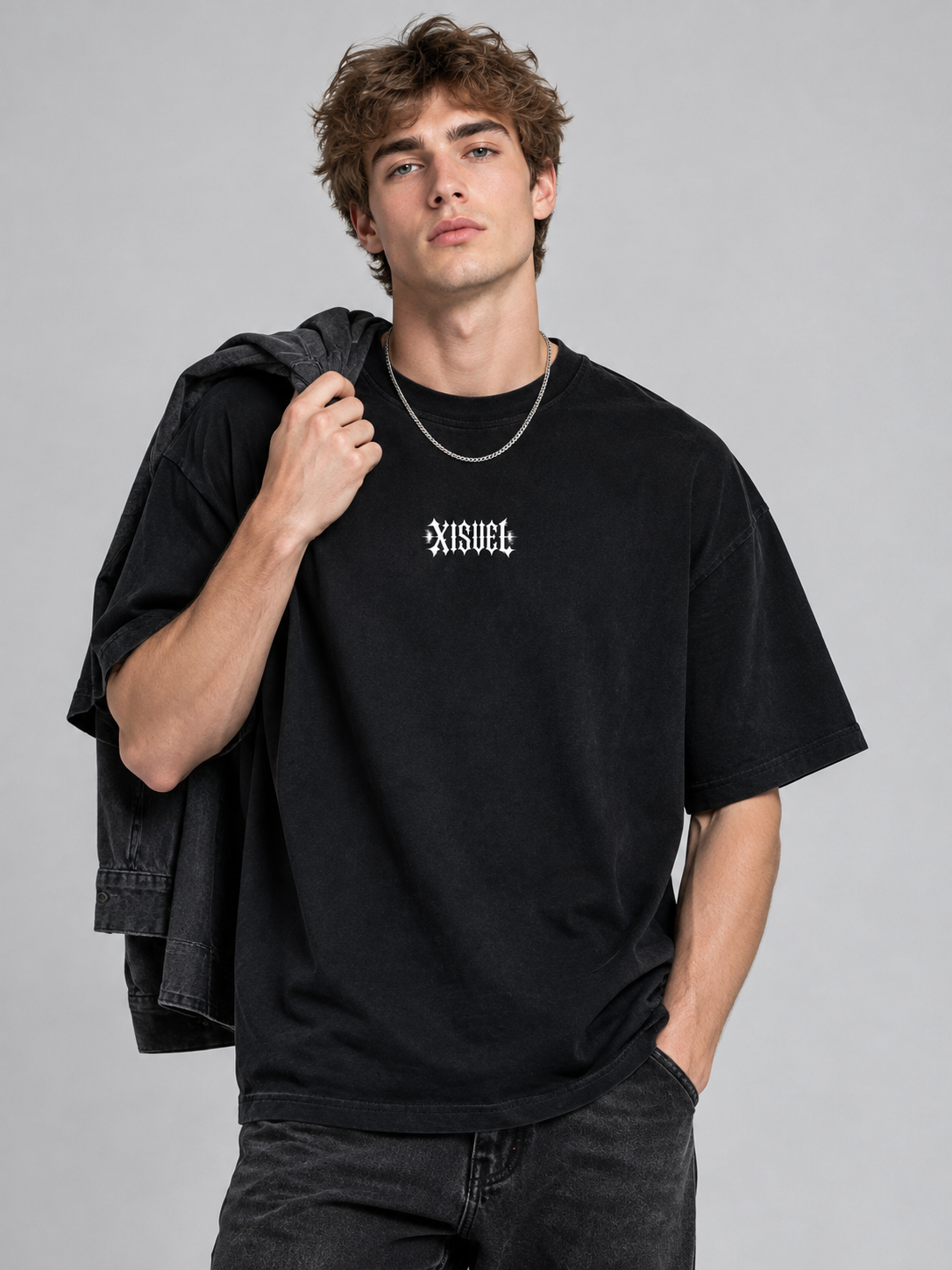 Male model with a charcoal overshirt over his shoulder wearing the black Aquarius Dark Graphic Tee with gothic XISVEL chest logo