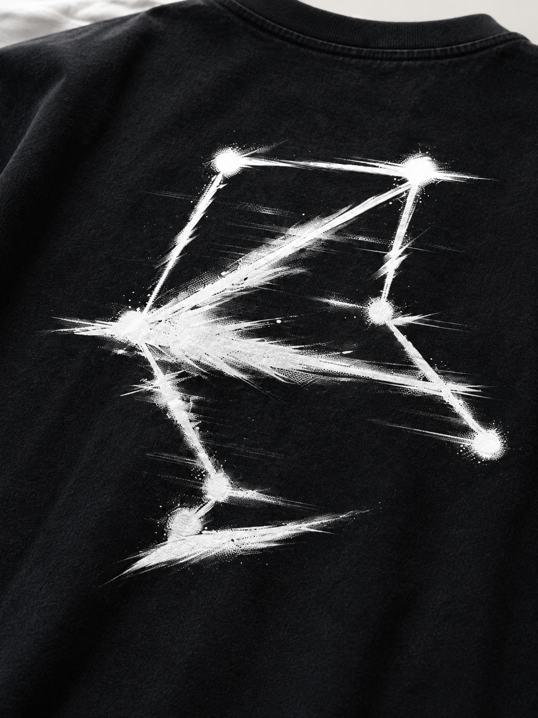 Close-up of the white Libra constellation back print on black cotton fabric